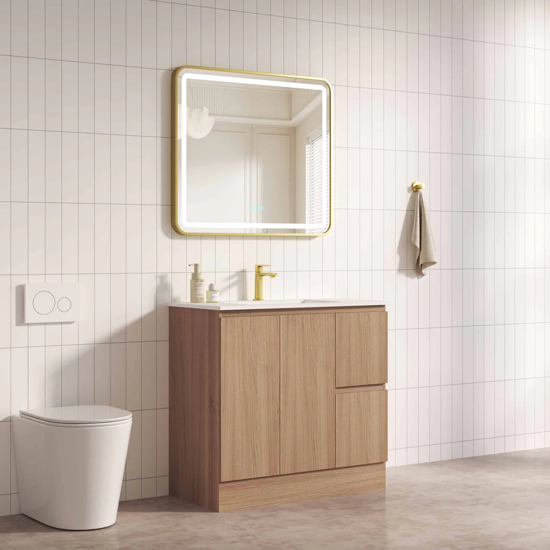Bathroom with wooden vanity, mirror, and toilet against a tiled wall.
