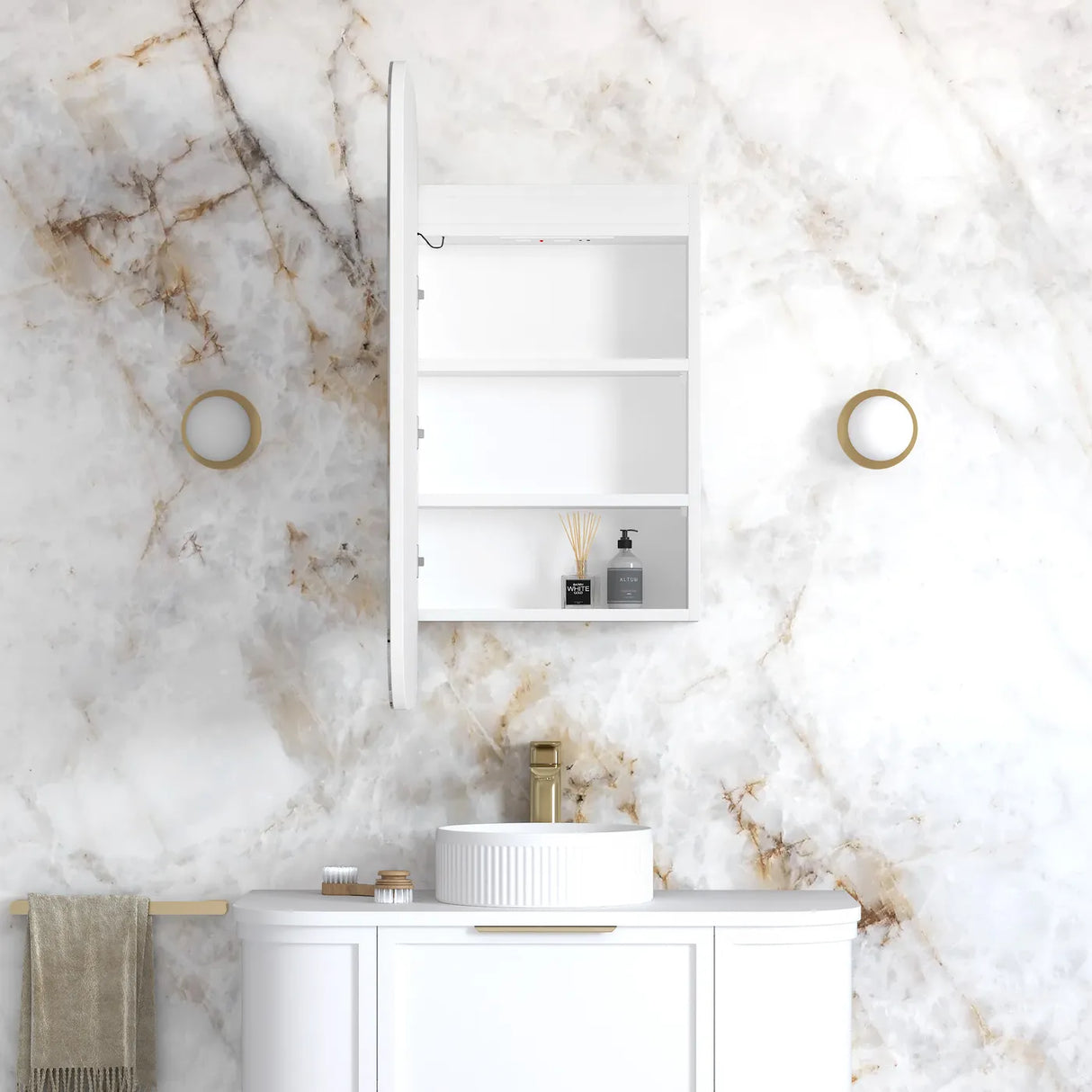 A white wall-mounted bathroom cabinet with three shelves, shown open with a sink, gold faucet, and marble-patterned wall behind it.