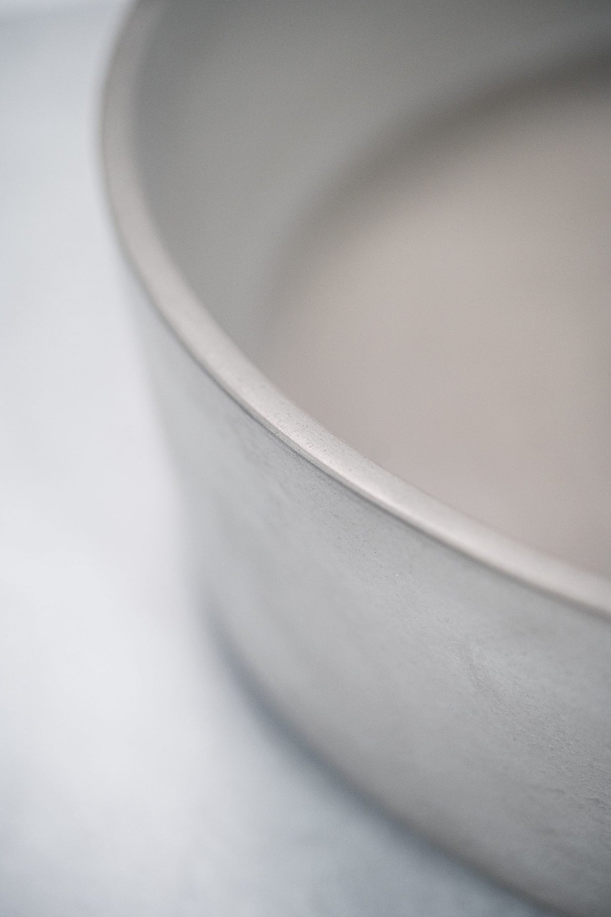 Close-up detail of the ARLO Round Concrete Basin in Cement Color, highlighting the smooth curved edge and natural matte texture for a refined minimalist aesthetic.
