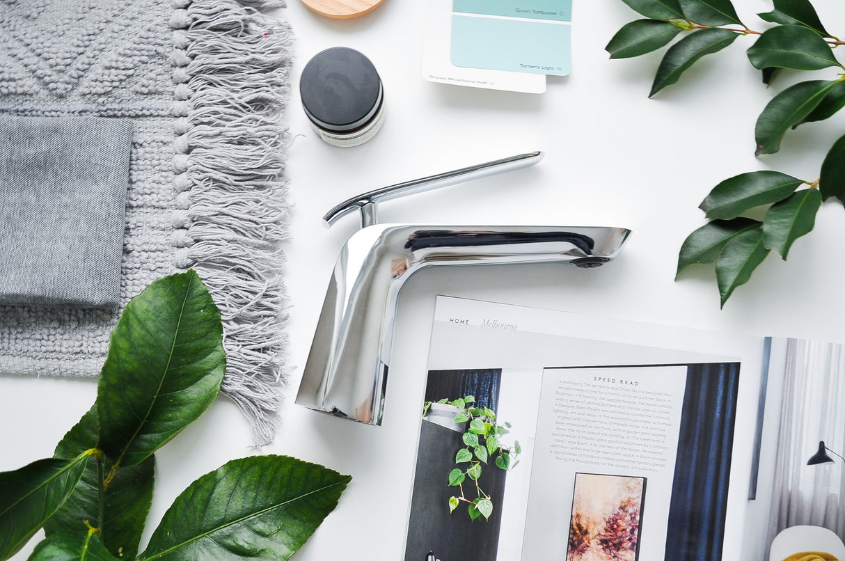 Eva Short Basin Mixer Chrome in table tap with magazine and leaves