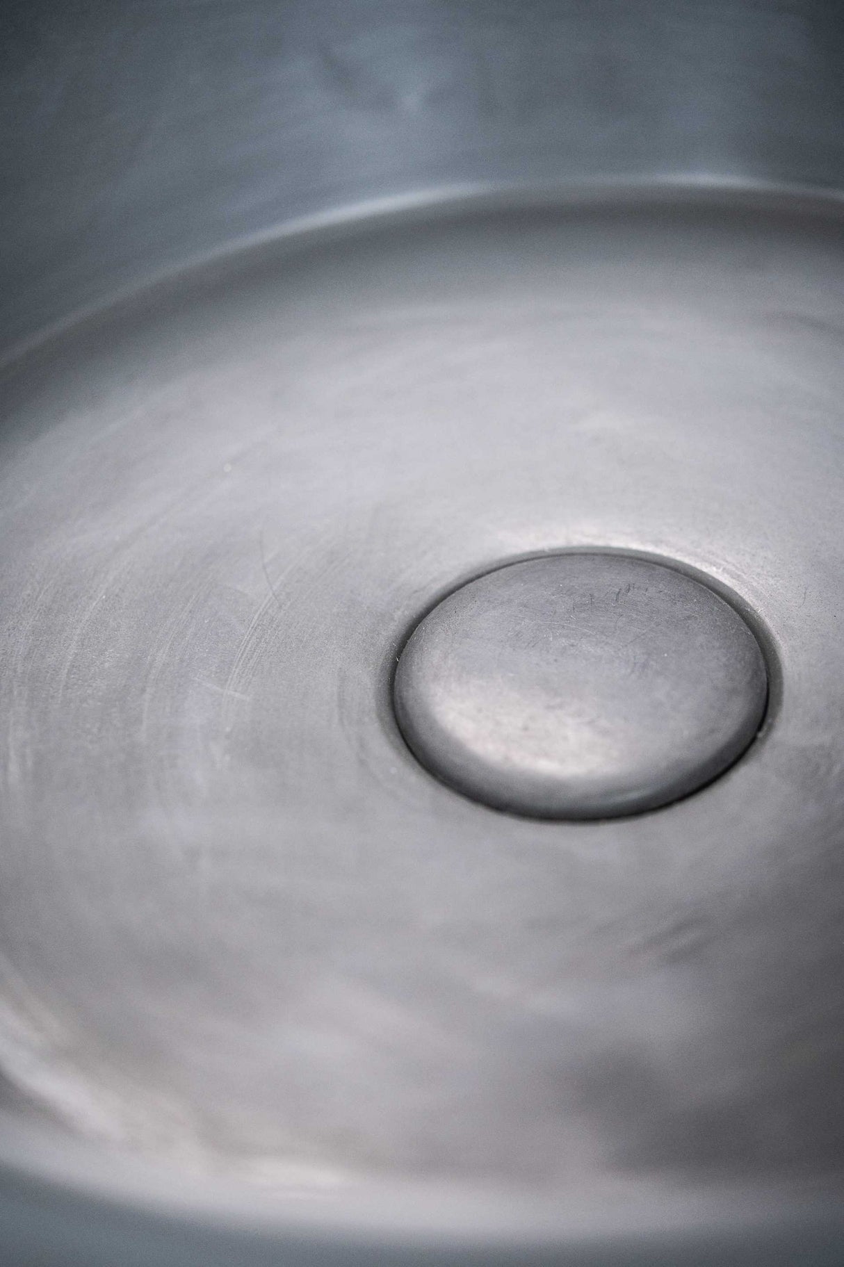 Close-up view of the ARLO Round Concrete Basin in Charcoal, focusing on the smooth circular interior and integrated drain, highlighting its minimalist and modern design.