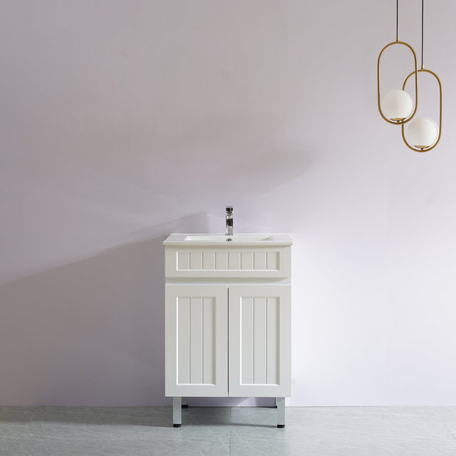 White bathroom vanity with sink against a white wall with modern pendant lights.