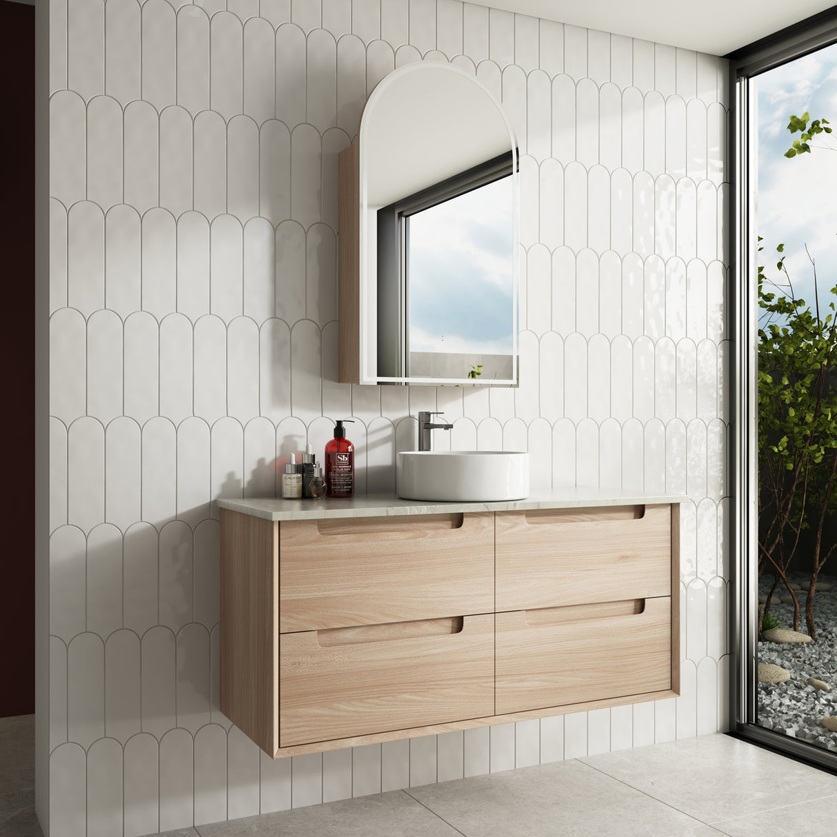 Bathroom vanity with wooden cabinet, round sink, and mirror against a tiled wall.