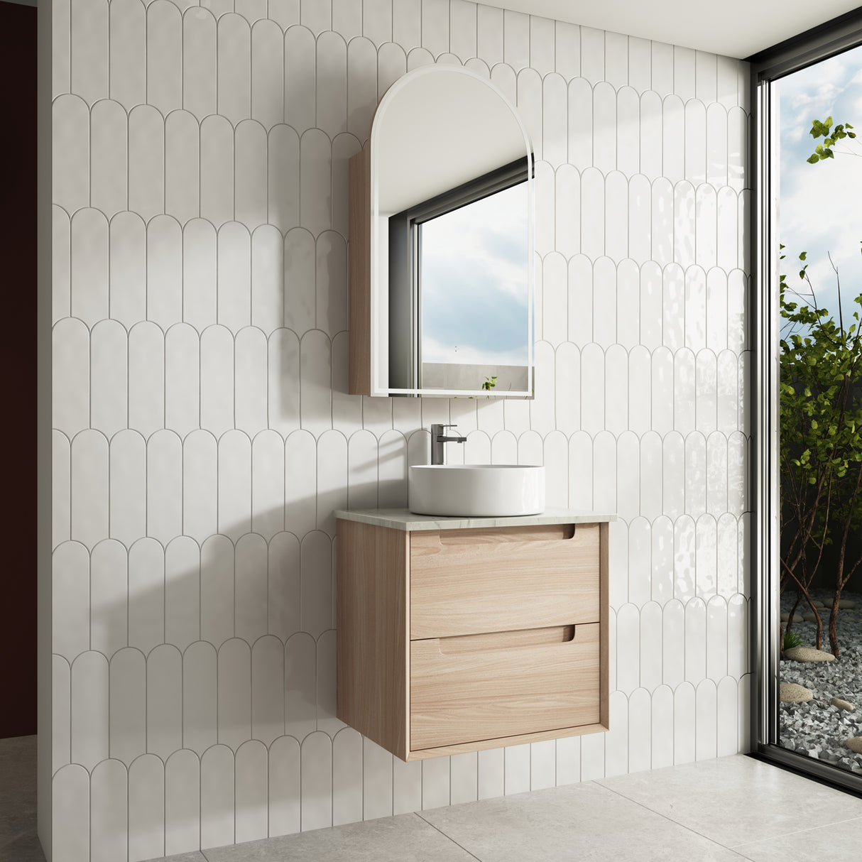 Bathroom with wooden vanity, sink, and mirror against a tiled wall.