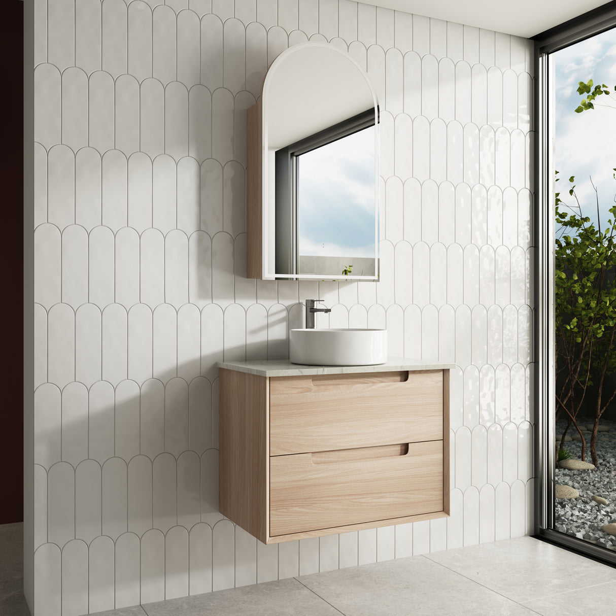 Bathroom with wooden vanity, white sink, and mirror against a tiled wall.