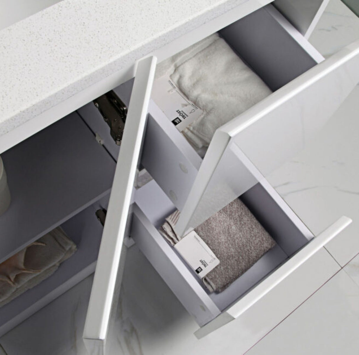 Open drawer with folded clothes inside, likely in a laundry room or storage area.