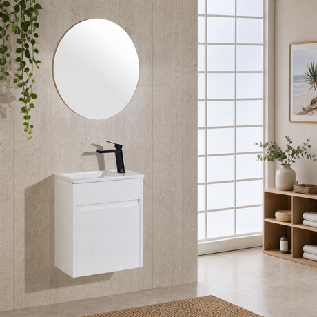 A modern wall-mounted bathroom vanity with a white cabinet, integrated white sink, black faucet, and a round mirror, shown in a bright beige-toned bathroom setting.