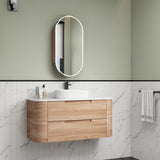 Bathroom vanity with wooden cabinet, white countertop, and mirror against a green wall.