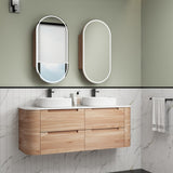 Bathroom vanity with wooden cabinets, white countertop, and two oval mirrors on a green wall.