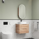 Bathroom interior with wooden vanity, mirror, and toilet.