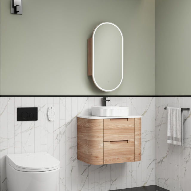 Bathroom interior with wooden vanity, mirror, and toilet.