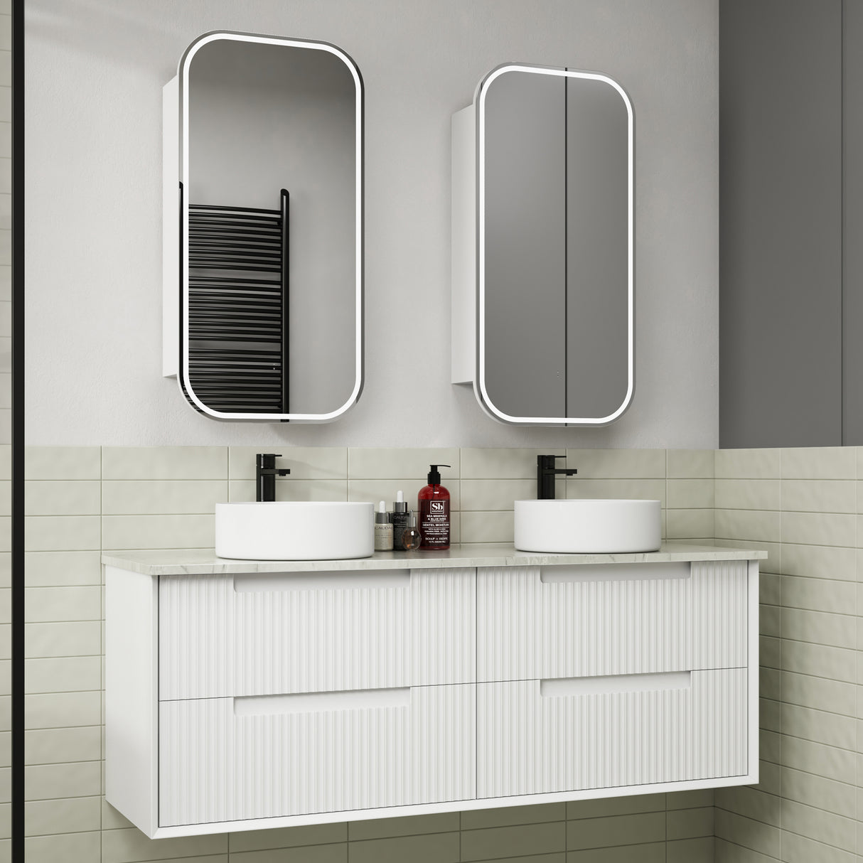 Bathroom vanity with two white sinks, mirrors, and toiletries.