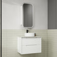 Bathroom setup with a white vanity unit, sink, and mirror against a tiled wall.