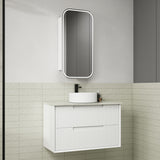 Bathroom vanity with white cabinet, round sink, and rectangular mirror on a tiled wall.