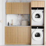 Modern laundry room with wooden cabinets and stacked washer and dryer.
