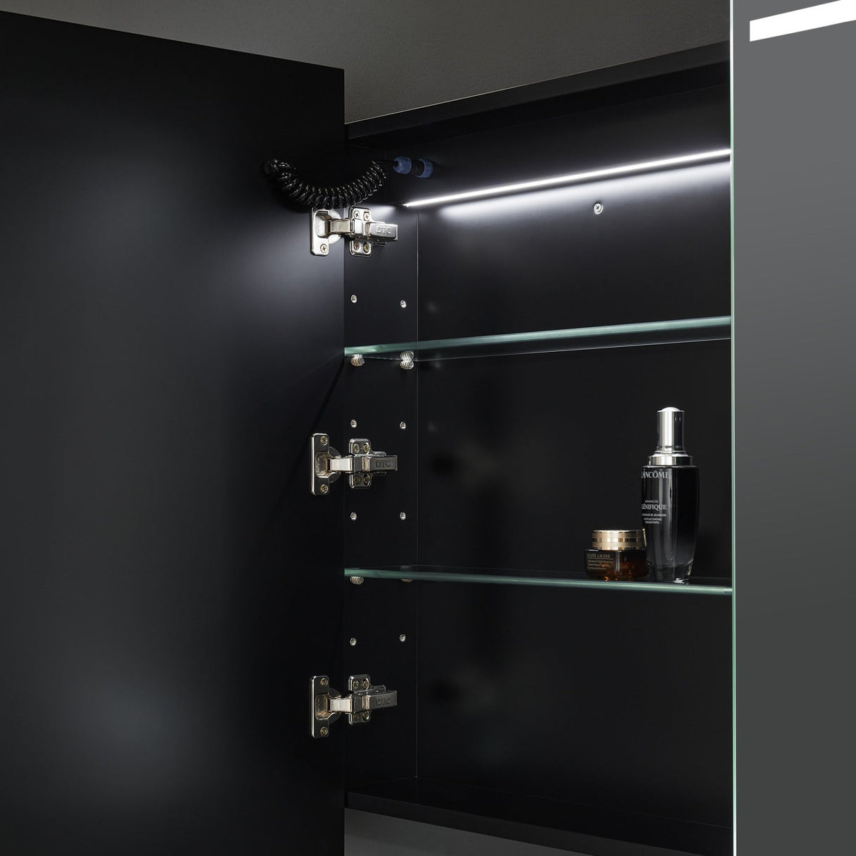 Black cabinet with glass shelves and a light fixture in a dark setting
