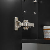 Close-up of a metallic cabinet hinge on a black cabinet with a Kiehl's product in the background.