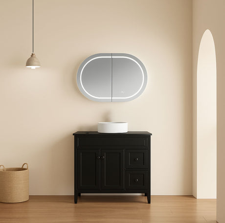 Bathroom vanity with a round mirror and light fixture on a beige wall.