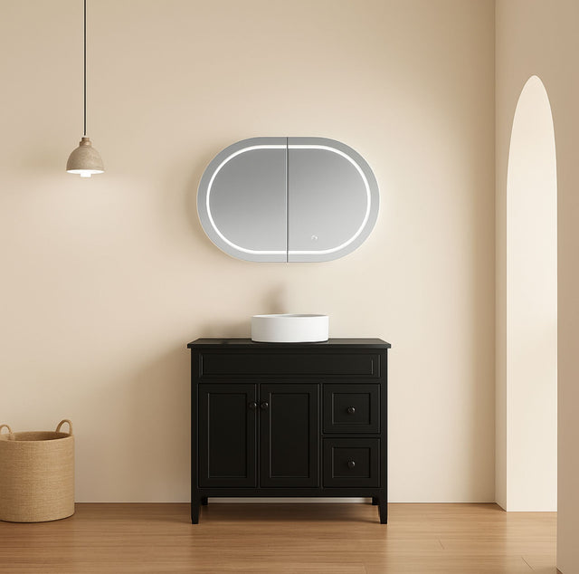 Bathroom vanity with a round mirror and light fixture on a beige wall.
