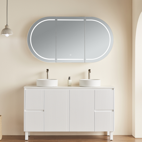 Bathroom vanity with two sinks and a large illuminated mirror above it.
