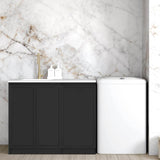 Matte Black finish laundry cabinet with a stone top and a sink, set against a marble wall in a room with wooden flooring.