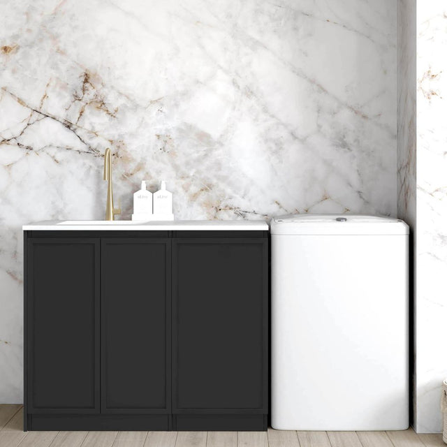 Matte Black finish laundry cabinet with a stone top and a sink, set against a marble wall in a room with wooden flooring.