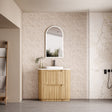Bathroom with wooden vanity, mirror, and decorative elements.