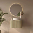 Modern bathroom setup with a round mirror, sink, and decorative elements.