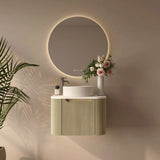 Modern bathroom setup with a round mirror, sink, and decorative elements.