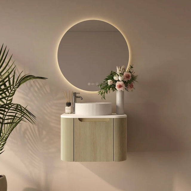 Modern bathroom setup with a round mirror, sink, and decorative elements.