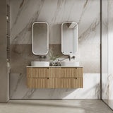 Bathroom vanity with wooden cabinet, two white sinks, and mirrors against a marble wall.
