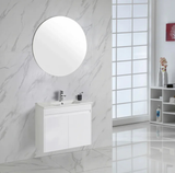 Bathroom with white vanity, round mirror, and marble walls.