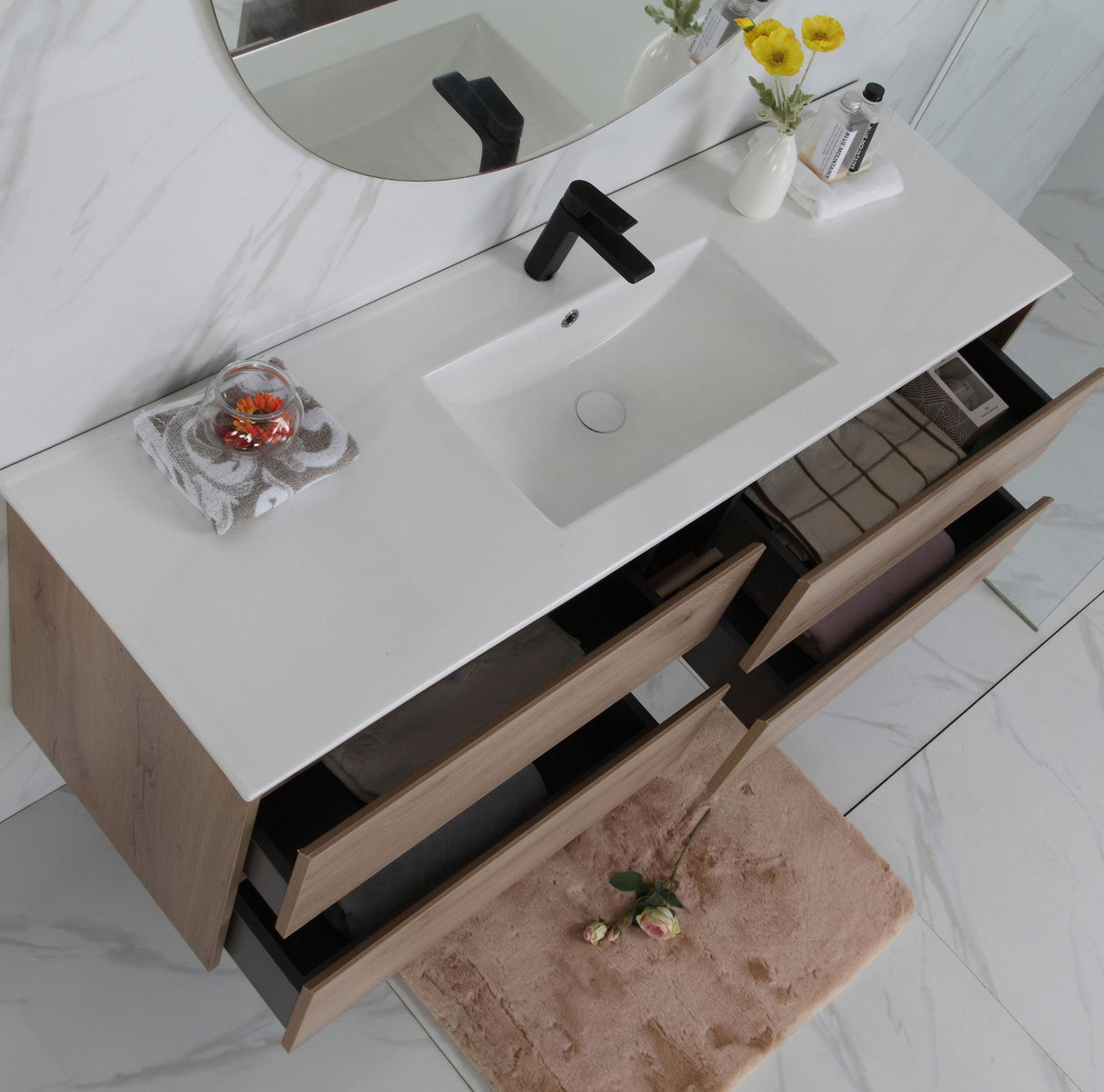 Bathroom vanity with sink, mirror, and decorative items on a light wood finish.