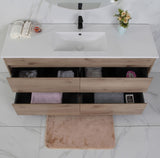 Bathroom vanity with wooden finish and white countertop, featuring a sink and open drawers.