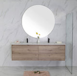 Bathroom vanity with wooden cabinets, round mirror, and marble walls.