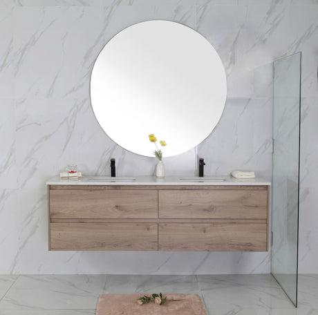 Bathroom vanity with wooden cabinets, round mirror, and marble walls.