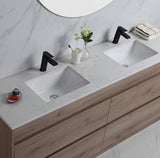Bathroom vanity with double sink, black faucets, and decorative items.