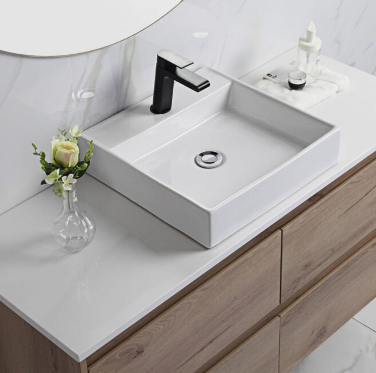 Bathroom vanity with white sink, black faucet, and decorative elements.
