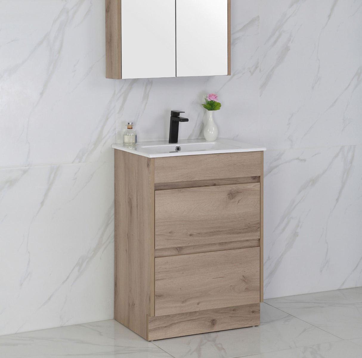 Bathroom vanity with wooden cabinet, white countertop, and mirror above on a marble wall background.