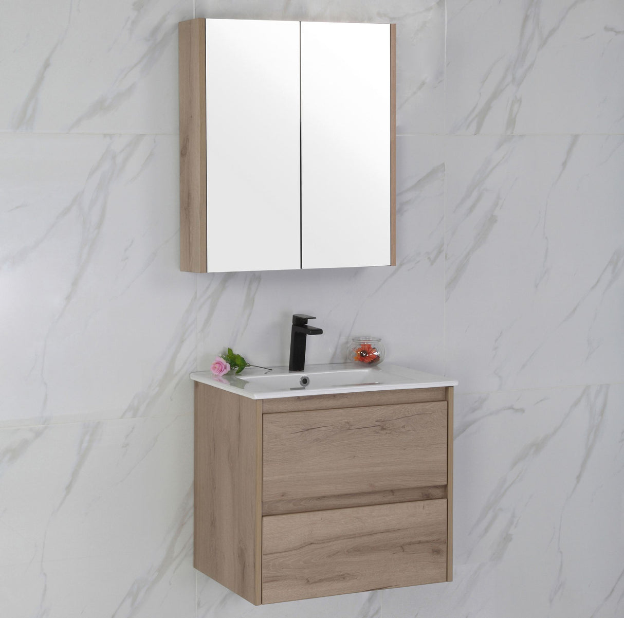 Bathroom vanity with mirror cabinet against a marble wall.