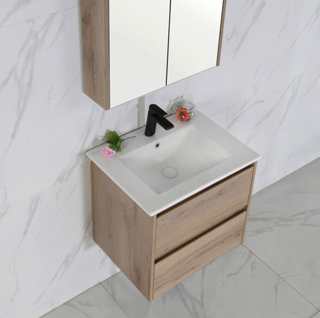 Bathroom vanity with white sink and wooden cabinet against a marble wall.