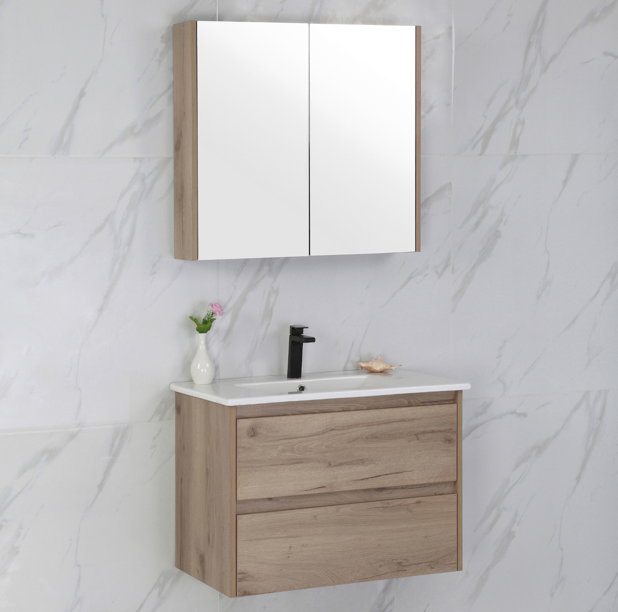 Bathroom vanity with wooden cabinet, white countertop, and mirror above on a marble wall.