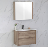 Bathroom vanity with wooden cabinet, white countertop, and mirror above on a marble wall.