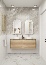 Bathroom with wooden vanity, white sinks, and marble walls.