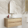 Bathroom vanity with wooden cabinet, white countertop, and mirror against a tiled wall.