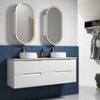 Bathroom with white vanity, two sinks, and oval mirrors against a blue tiled wall.