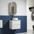 Bathroom setup with white vanity, round mirror, and blue tiled wall.