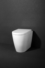 Minimalist ANITA In Wall Toilet Pan (Round) with a sleek, modern design, set against a textured dark gray background.