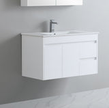 White bathroom vanity with sink and faucet against a gray wall.
