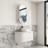 Modern bathroom with white vanity, round mirror, and marble-patterned wall.